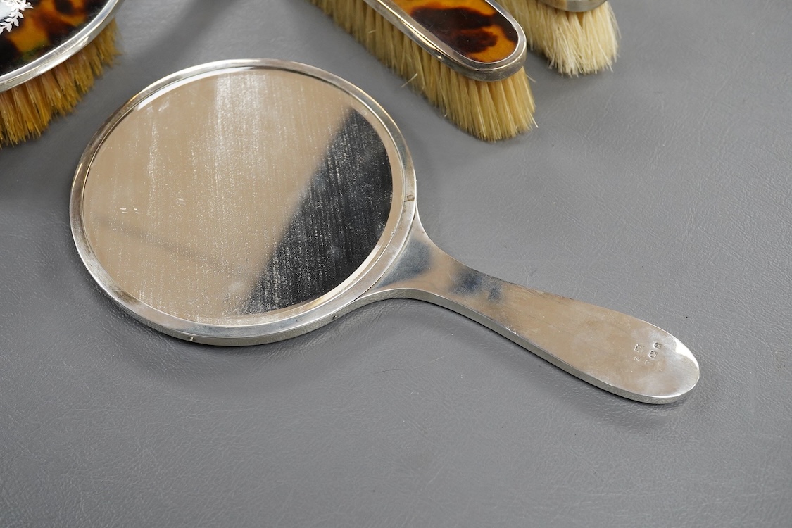 A matched George V silver and tortoiseshell mounted four piece mirror and brush set, Birmingham, 1927/8/9, mirror 22.7cm.